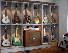 guitars are lined up on shelves in a room