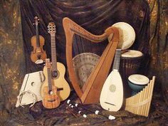 an assortment of musical instruments sitting on top of a cloth covered table next to a curtain