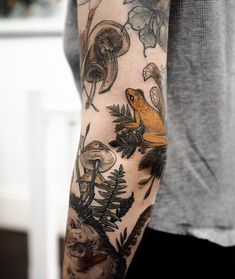 a person with a tattoo on their arm and some animals in the woods behind them