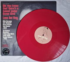 a red vinyl record sitting on top of a white sheet