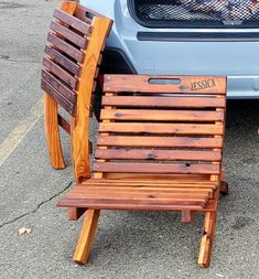 two wooden chairs sitting in front of a car