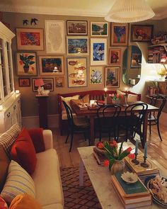 a living room filled with furniture and lots of pictures on the wall above it's coffee table