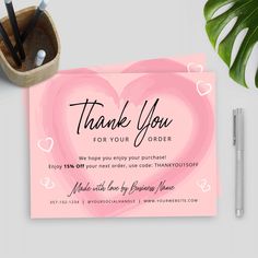 a thank card with a pink heart on it next to some pens and pencils