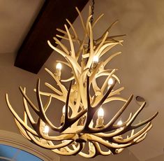 a chandelier made out of antlers hanging from the ceiling