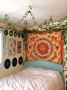 a bed with a sun tapestry hanging on the wall next to it's headboard