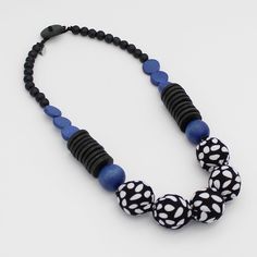 "Introducing the Imani Necklace from Sylca Designs - a refined statement piece that's sure to have all eyes on you! This artful, black and blue design features painted and fabric-covered wooden beads, which are strung with a  black clasp closure. It's sure to bring a luxurious, elegant touch to all your favorite necklines and looks. Celebrate your unique style and wear your own Imani necklace with pride! Necklace length: 18\"  Care Instructions: Remove jewelry when applying perfumes, creams, was African Necklaces, Pride Necklace, Funky Necklace, Necklace Wood, Bubblegum Necklace, Necklace Bead, Bold Necklace, African Necklace, Wood Necklace