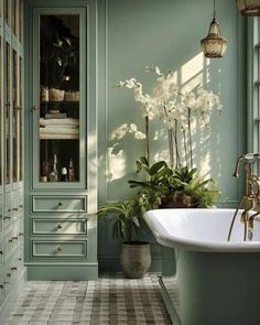 a bath room with a tub a sink and some plants in the middle of it