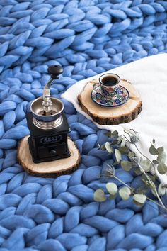 a blue blanket with a coffee pot on it and a tea kettle sitting on top