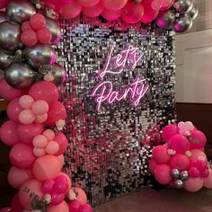 pink and silver balloons are on display in front of a sequin backdrop that says let's party