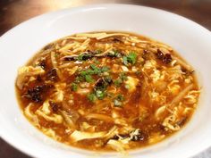 a white bowl filled with noodle soup on top of a table