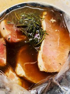 some meat and vegetables are in an ice bag on the table with water inside it