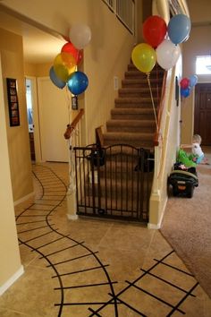 some balloons that are on the ground in front of a stair case and carpeted floor