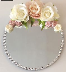 a mirror with flowers and pearls on it