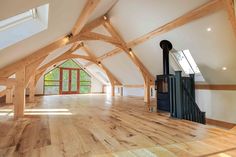 an empty room with wooden floors and vaulted ceilings, is seen in this image from the inside