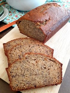 two slices of banana bread sitting on top of a cutting board next to a bowl