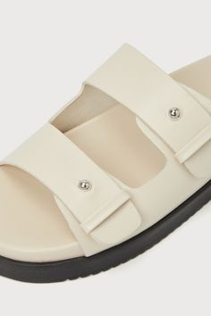 Slide out the door looking effortlessly chic in the Steve Madden Mariel Bone Leather Studded Flatform Slide Sandals! Smooth genuine leather shapes these essential sandals that feature a rounded footbed and wide vamp straps with shiny studded details. An easy slide-on design and a contrasting black flatform heel complete the casually cute look! 0. 75" rubber heel. Cushioned insole. Rubber sole has nonskid markings. Genuine leather upper, balance man made materials. Imported. Lulus | Mariel Bone L Classic Leather Footbed Sandals For Summer, Classic Open Toe Footbed Sandals For Spring, Elegant Leather Footbed Sandals For Summer, Classic Summer Mules With Buckle Closure, Classic Spring Footbed Sandals With Textured Footbed, Classic Summer Footbed Sandals With Removable Insole, Summer Classic Footbed Sandals With Removable Insole, Classic Leather Footbed Sandals For Spring, Elegant Spring Footbed Sandals With Removable Insole