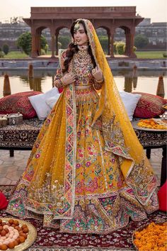 a woman in a yellow bridal gown standing next to some donuts on a table