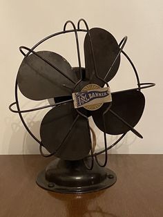 a metal fan sitting on top of a wooden table