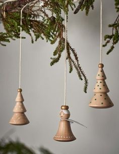 three wooden bells hanging from a tree branch