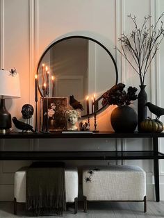 a table with candles, vases and other items on it in front of a mirror