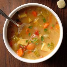 a bowl of soup with carrots, celery and tofu in it