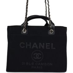 This Small Deauville bag is made of black canvas fabric with light gold tone hardware has a large CC signature and Chanel logo on the front, removable pouch and interwoven light gold tone chain link and black leather shoulder straps.The interior is lined in white canvas and has two open pockets on the front wall and a zipper pocket with a Chanel pull on the rear wall.Collection: 22BOrigin: ItalyCondition: New and never worn (plastic on hardware)Accompanied by: Chanel box, Chanel dustbag, carebook, retail UPC, RFID, removable pouch and ribbon Measurements: 13" width x 10" height 5.75" depth; 3.5" top handles, 11" shoulder straps Luxury Canvas Evening Bags, Luxury Evening Canvas Bags, Black Canvas Evening Bag, Classic Canvas Evening Bag, Elegant Coated Canvas Bags With Logo Hardware, Elegant Black Canvas Shoulder Bag, Black Shoulder Bag With Logo Hardware In Coated Canvas, Black Coated Canvas Shoulder Bag With Logo Hardware, Elegant Evening Canvas Bag