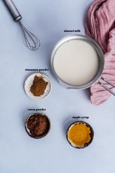 ingredients to make chocolate cake sitting on a table next to a whisk and cloth