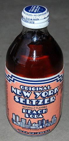 a bottle of new york seltzer sits on the floor in front of a gray background