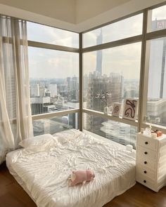 a bedroom with a large window overlooking the city