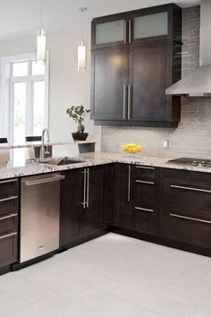 a kitchen with dark wood cabinets and stainless steel appliances