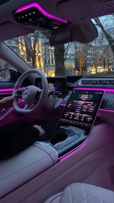 the interior of a modern car with purple lighting and dashboard lights in front of it