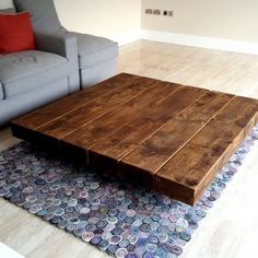 a living room with a couch, coffee table and rugs on the hardwood floor