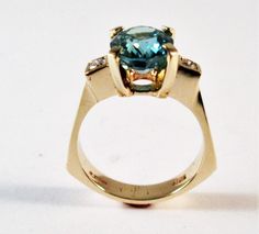 A 14kt yellow gold original designer ring Center stone is a 10x8 mm oval Swiss blue topaz Side diamonds are two round 2.5mm si1 g/h color tdw .14cts Can be ordered in white gold, yellow gold, rose gold, and platinum Comes in all sizes Comes in a beautiful box 100% MONEY BACK GUARANTEE Modern Topaz Ring With Gemstone Accents, Modern Topaz Ring With Center Stone In Yellow Gold, Modern Yellow Gold Topaz Ring With Center Stone, Modern Topaz Ring With Gemstone Accents For Anniversary, Modern Oval Topaz Ring With Prong Setting, Swiss Blue Topaz Ring, Mystic Topaz, Round Rings, Swiss Blue Topaz