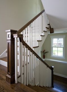 an empty staircase in a house with white railing and wood handrails on the sides