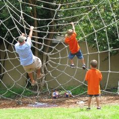 three children are playing in a spider web with one child reaching up to catch the ball