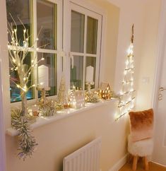 a window sill filled with christmas decorations and lights next to a radiator