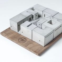 a model of a house on top of a wooden board