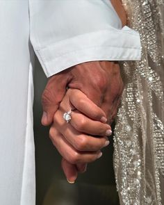 the bride and groom hold their hands together