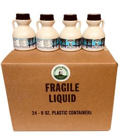 four gallon jugs of liquid sitting on top of a cardboard box with the label fragile liquid