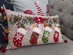 two christmas stockings pillows sitting on top of a couch