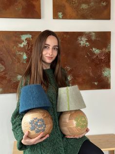 a woman holding two wooden balls in her hands