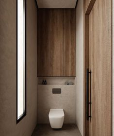 a bathroom with wooden cabinets and a white toilet in the middle, next to an open door