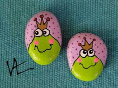 two painted rocks with faces and crowns on them