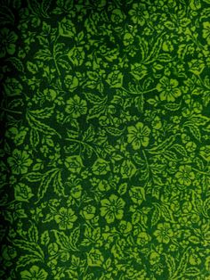 a green wallpaper with leaves and flowers in the center, as well as an image of