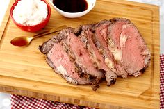 the meat is sliced and ready to be served on the cutting board with sauces