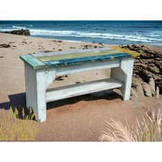 a wooden bench sitting on top of a sandy beach