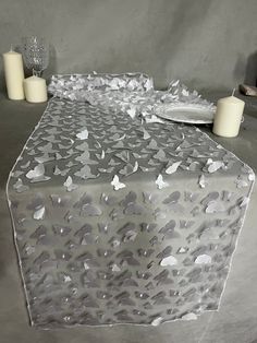 the table is covered with silver foil and candles are on the table next to it