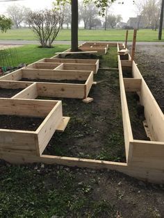 several wooden raised garden beds sitting in the grass