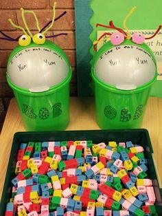 two plastic cups filled with legos sitting next to each other on top of a table