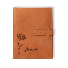 a brown leather journal with the word bonnie written on it and a flower in black ink